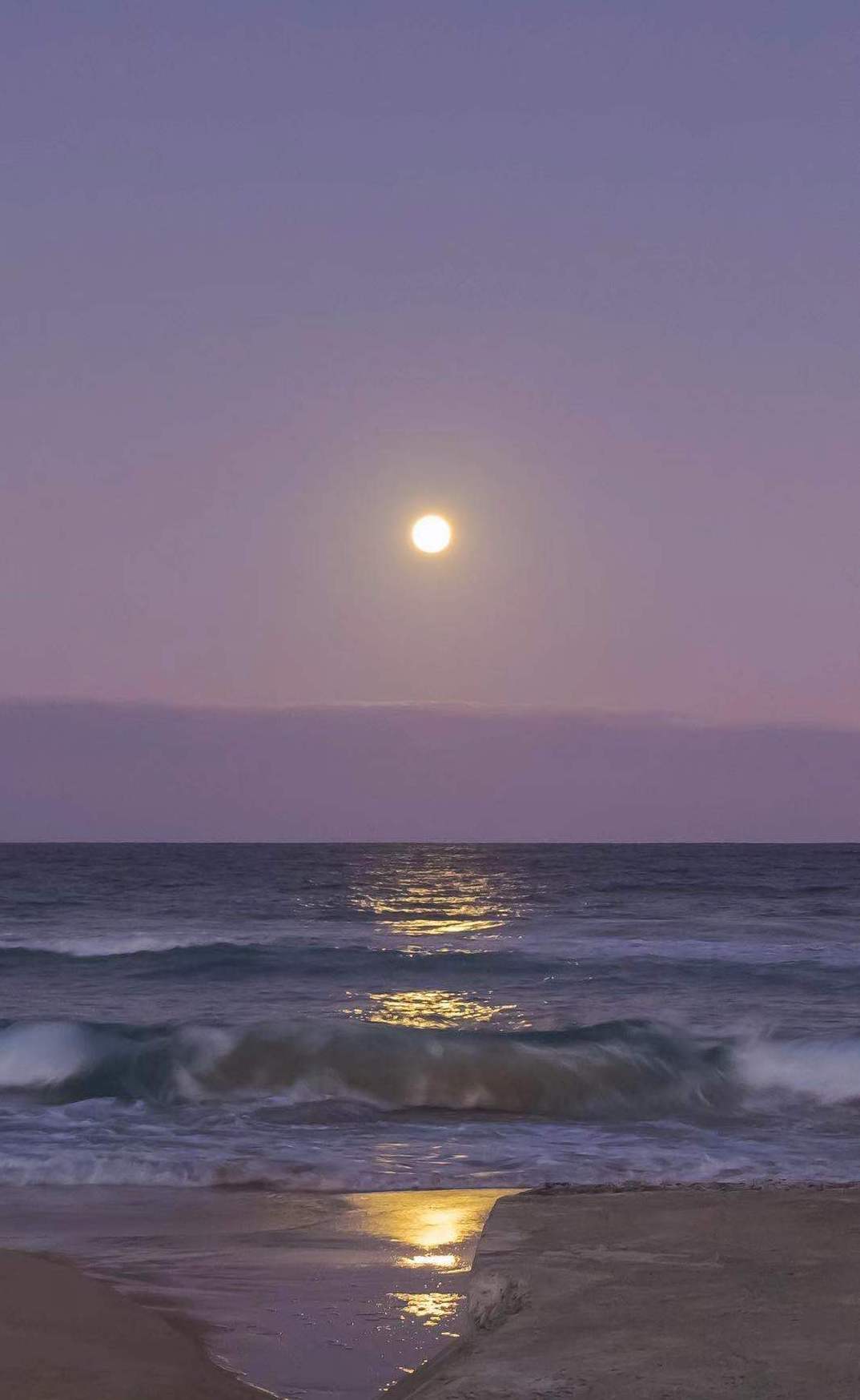 moon and purple sunset reflected on the ocean water