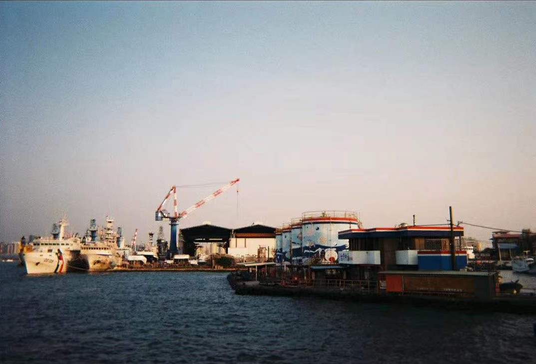 A far view of factory buildings near an ocean