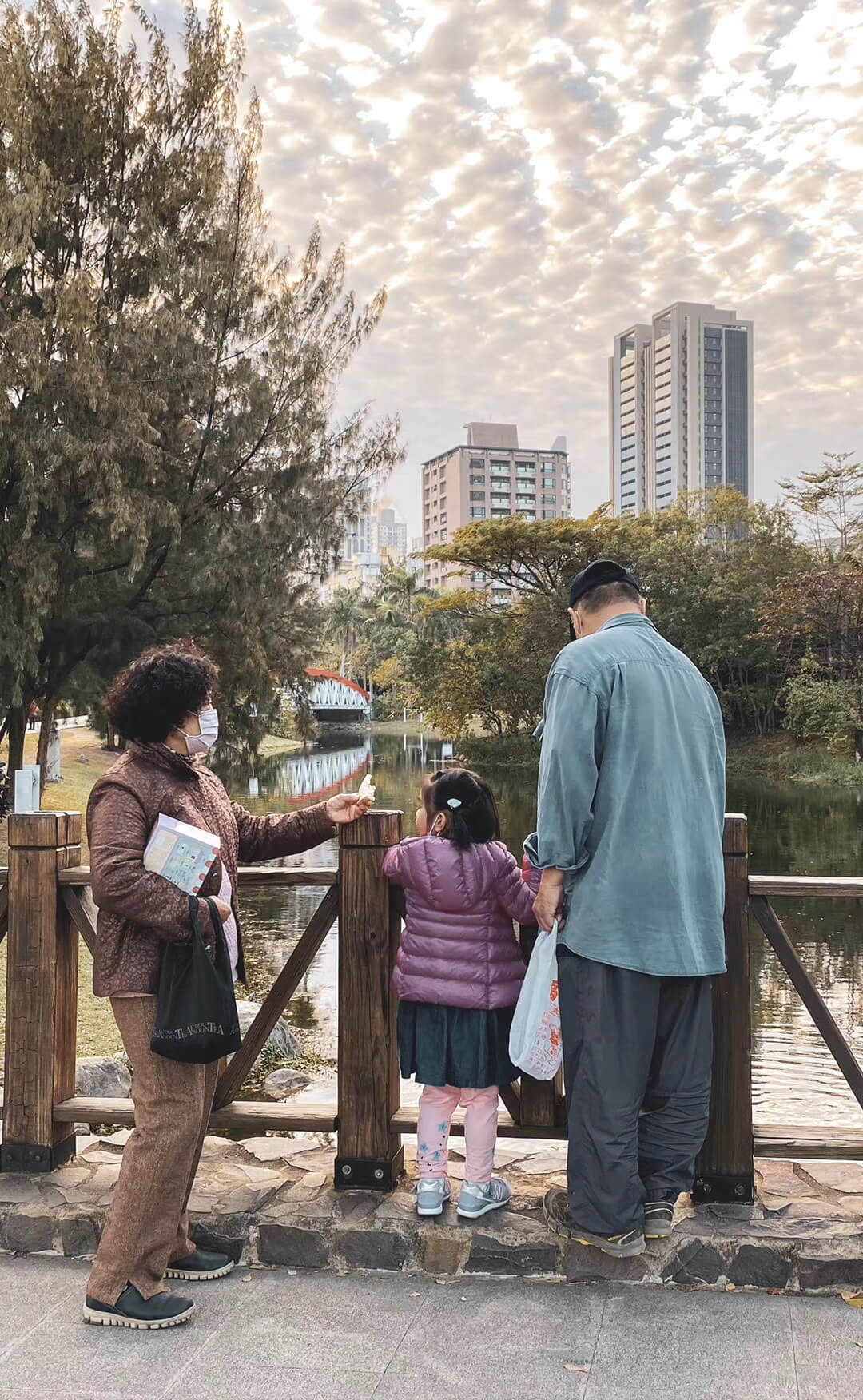 A back view of an old woman and old man next to a small girl